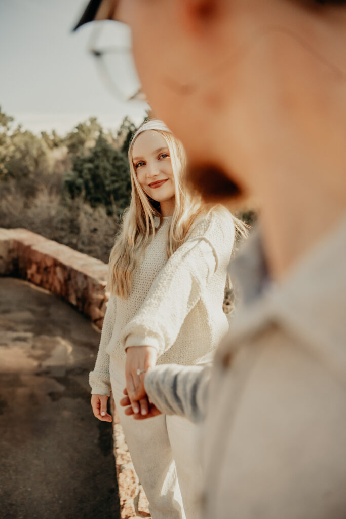 Nick blurry in the foreground holding Callies hand as they gaze into each others eyes at the Garden of the Gods