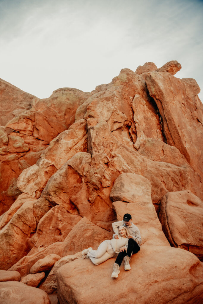 Callie and Nick embracing joyfully after the proposal, with the red rock formations of Garden of the Gods in the background