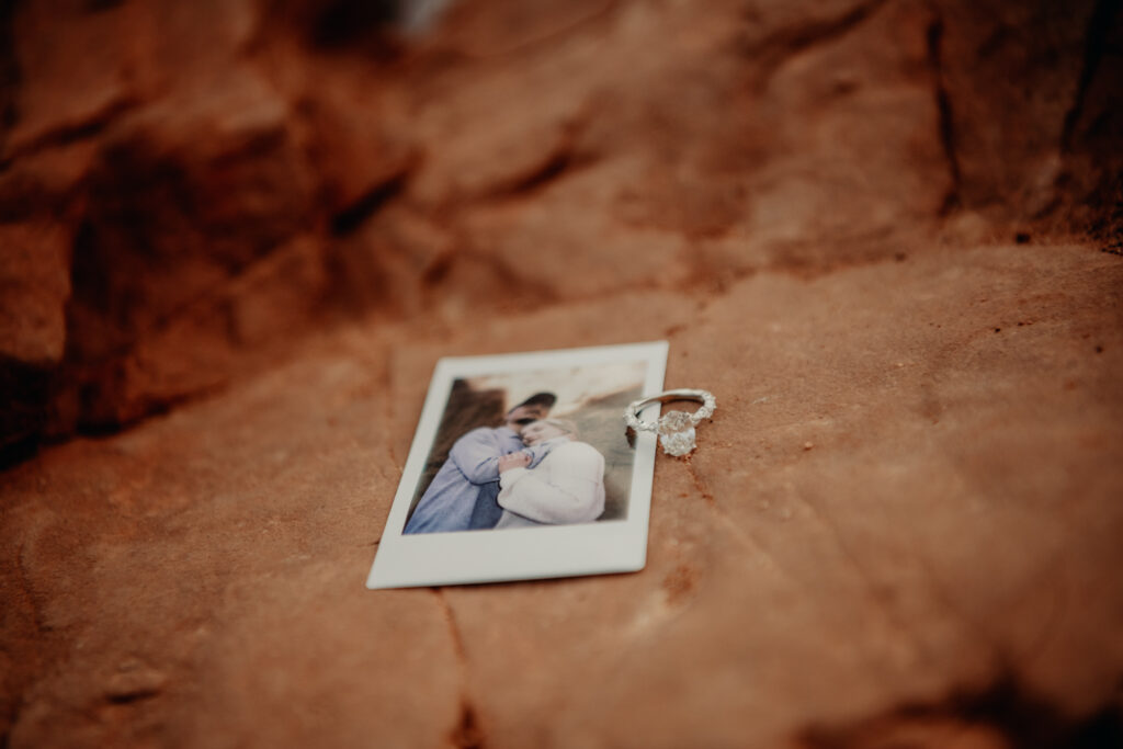 Close up of the ring against the polaroid picture taken of Callie and Nick on a rock at the Garden of the Gods
