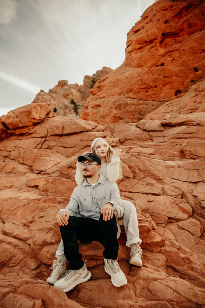 Sitting down pose with Callie behind Nick resting her elbows on his shoulders playing with her hair as they look in opposite directions at the Garden of the Gods