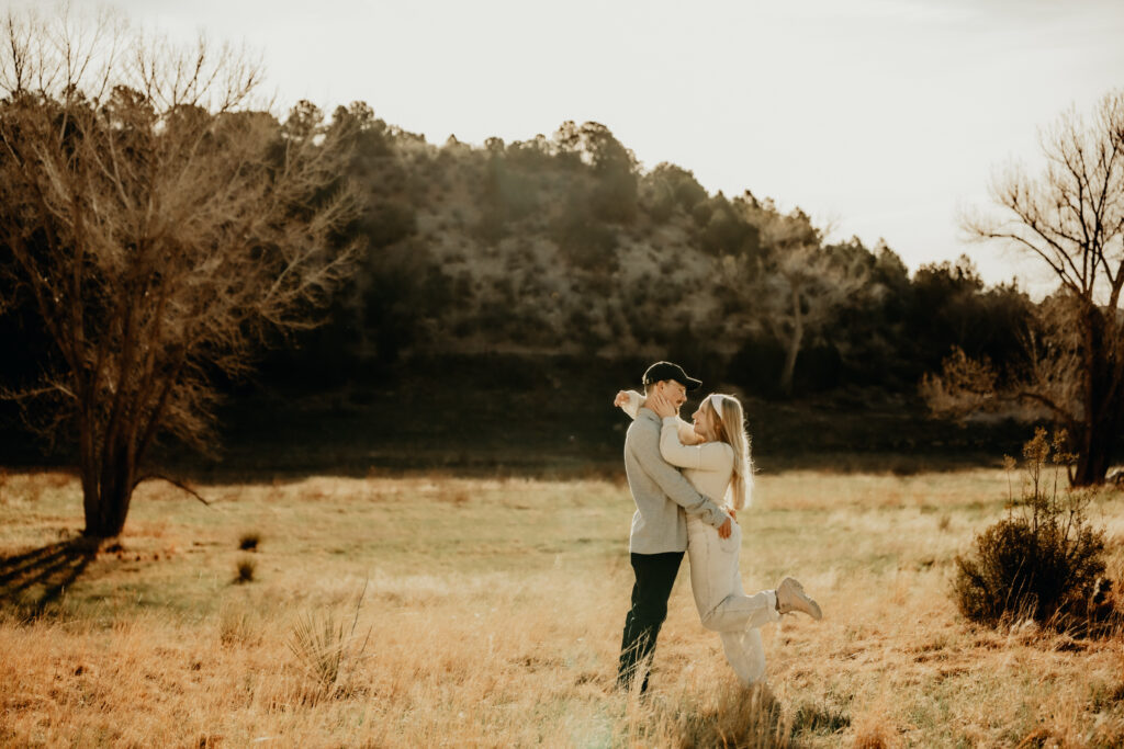 Callie posing for a portrait during a morning photo session at Garden of the Gods, unaware of the upcoming surprise proposal. Chest to Cheset as she holds on to his face with arms over his shoulders about to kiss with the famous foot pop.