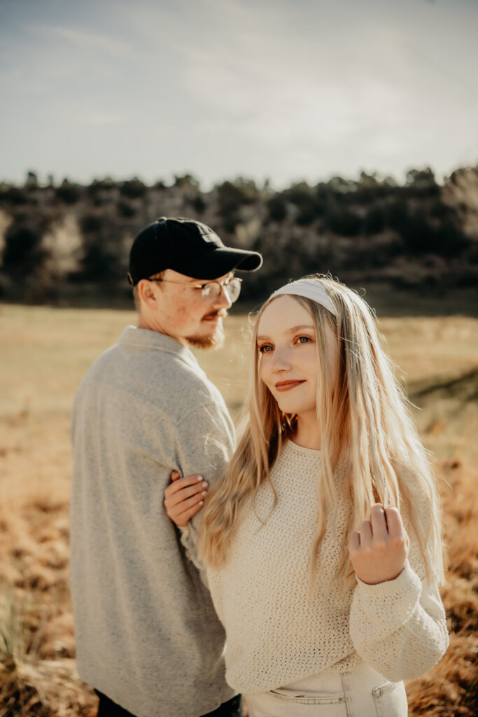 Callie posing for a portrait during a morning photo session at Garden of the Gods, unaware of the upcoming surprise proposal. Playing with her hair while Nick admire her