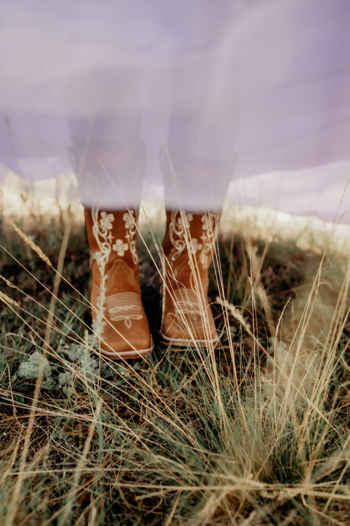 brown cowgirl boot detail shot in the grass of evergreen with the purple dress showing