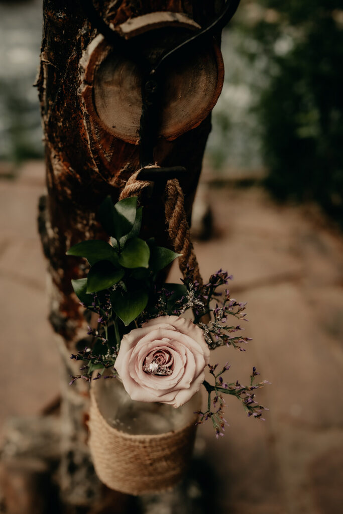 Ceremony site at Romantic Riversong Inn in Estes Park featuring the florals they decorate with in mason jars and the ring for a detailed shot