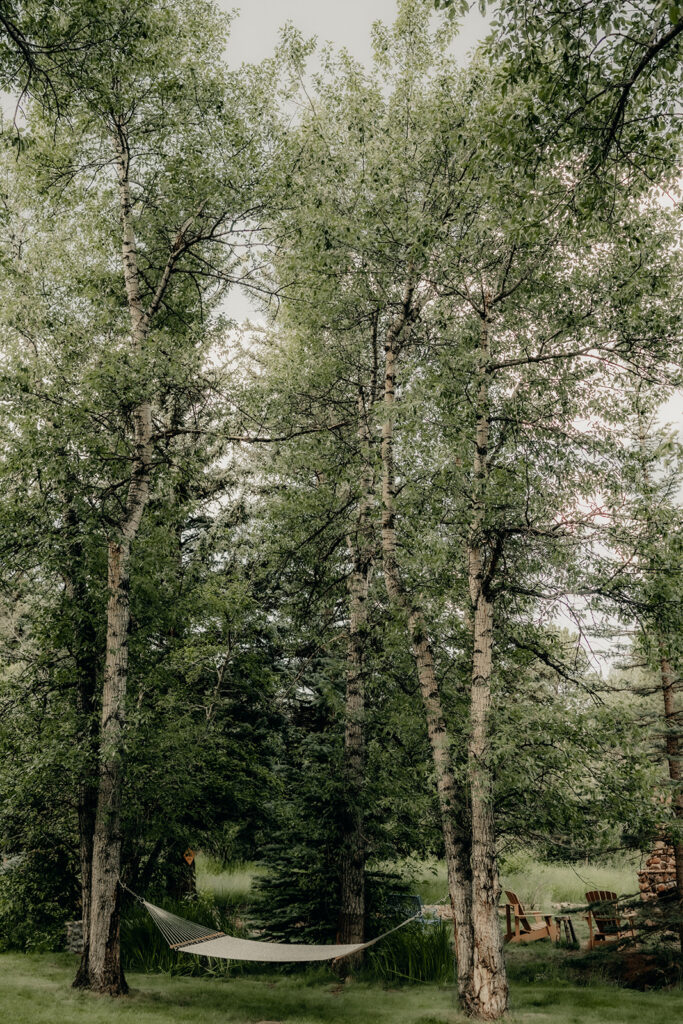 Romantic Riversong Inn in Estes Park cozy hang out area with a hammock under the trees