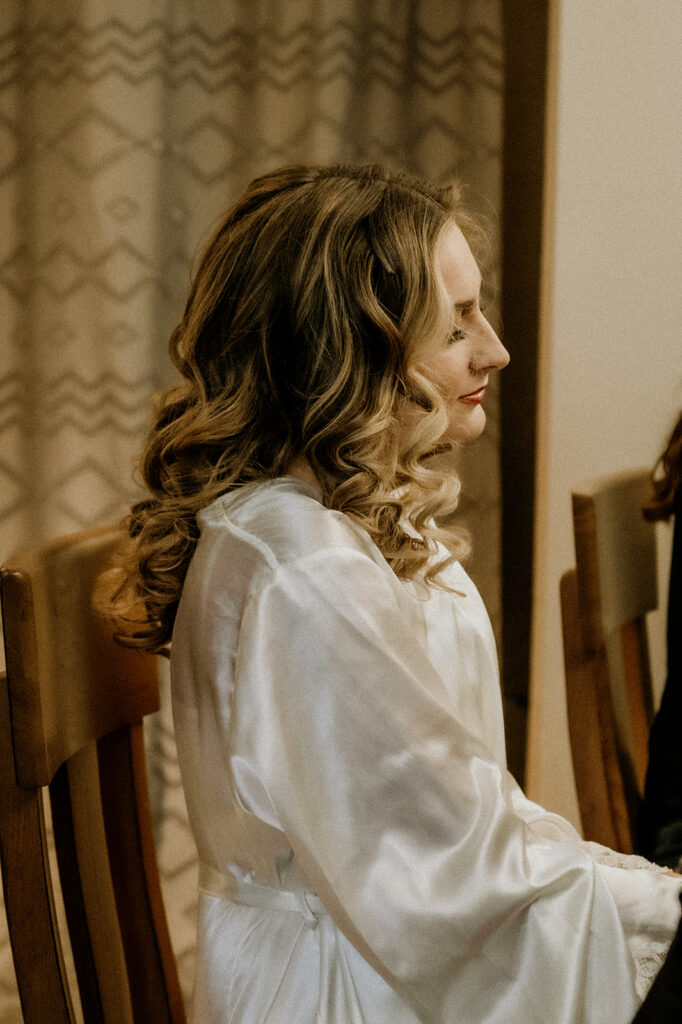 bride getting her hair and makeup done in her bridal robe