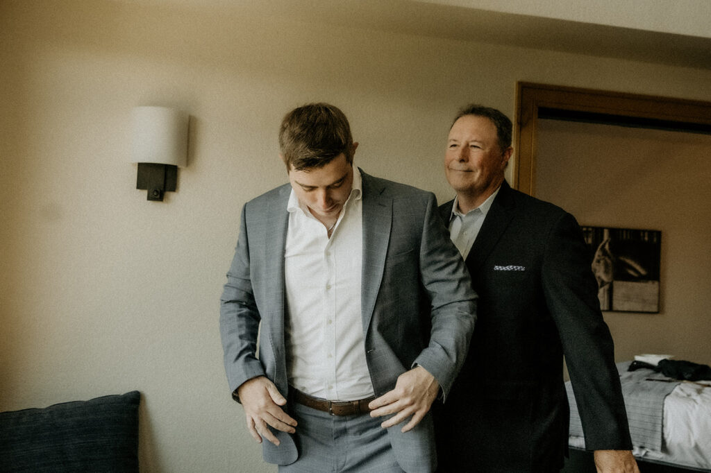 Dad and groom getting ready before heading out to the ceremony site at Yampa Botanical Gardens just minutes away from their hotel.
