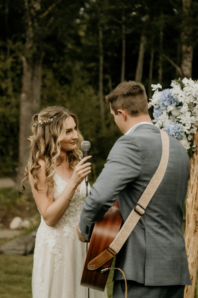 bride and groom singing a song together as a married couple for their guests at Yampa River Botanic Gardens