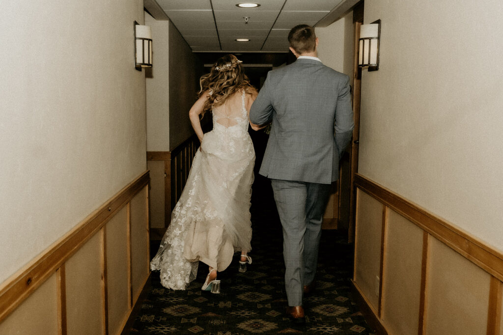 bride and groom kissing running down the hallway at their resort hotel in Steamboat Springs at the Steamboat Grand