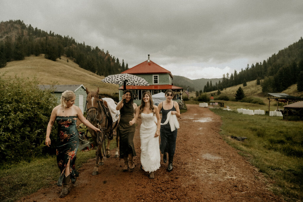 walking to the first look in the rain when the bride wasn't able to get on the horse to ride with her booted foot