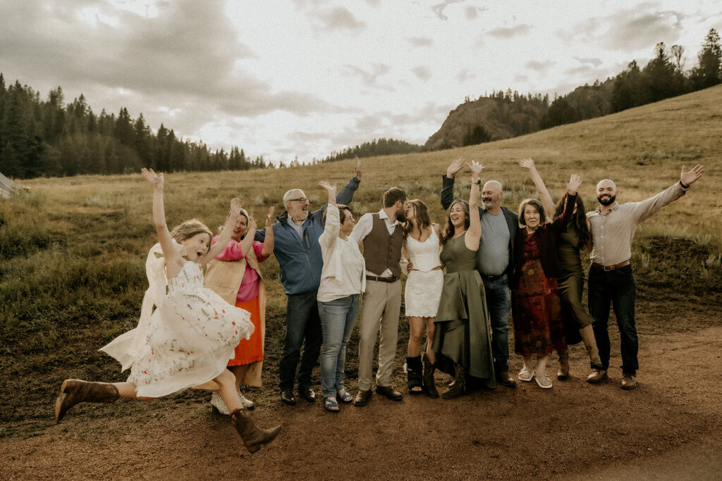 wedding family formal photos with their daughter jumping in frame