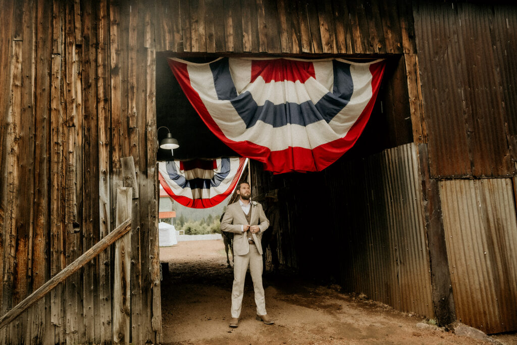 groom awaiting for his bride in the horse barn for the first look