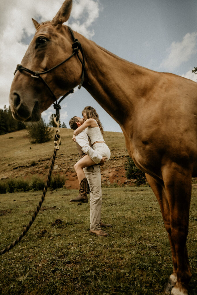 newly weds kissing with the horse in the foreground at the elk galde ranch